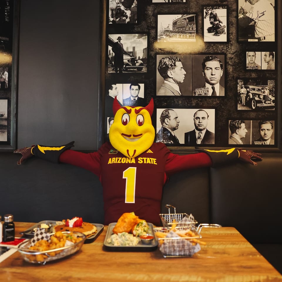 Arizona State mascot seated with food at the Tempe location